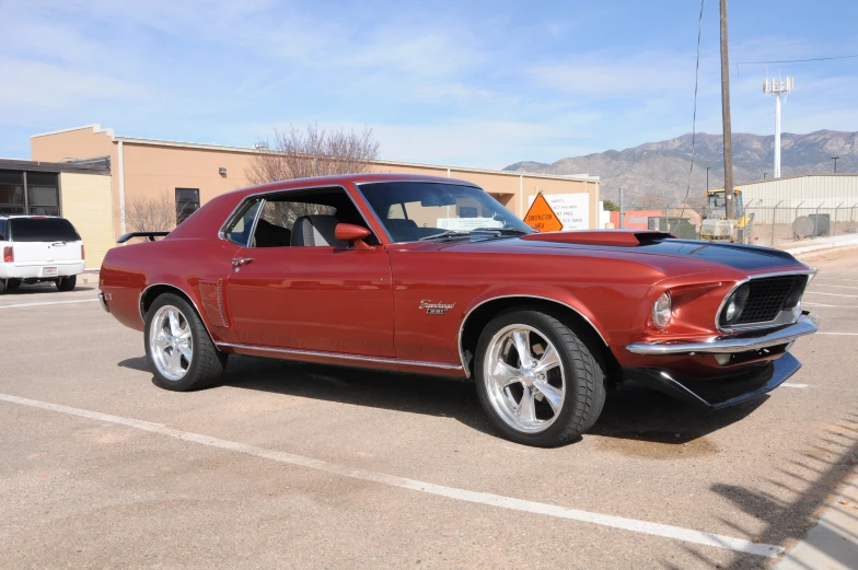 an older mustang sits in a parking lot