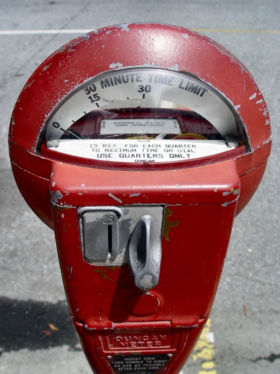 a red parking meter that is empty and has no meter on it