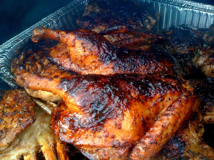 meat cooking in foil pans in the middle of food