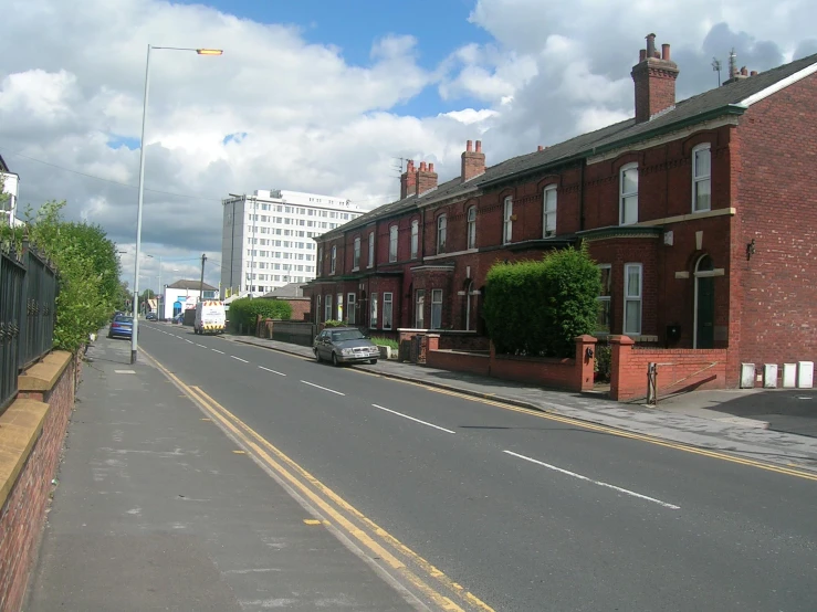 a wide paved road with buildings in the background