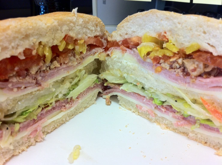 a sub sandwich sitting on top of a table next to a computer