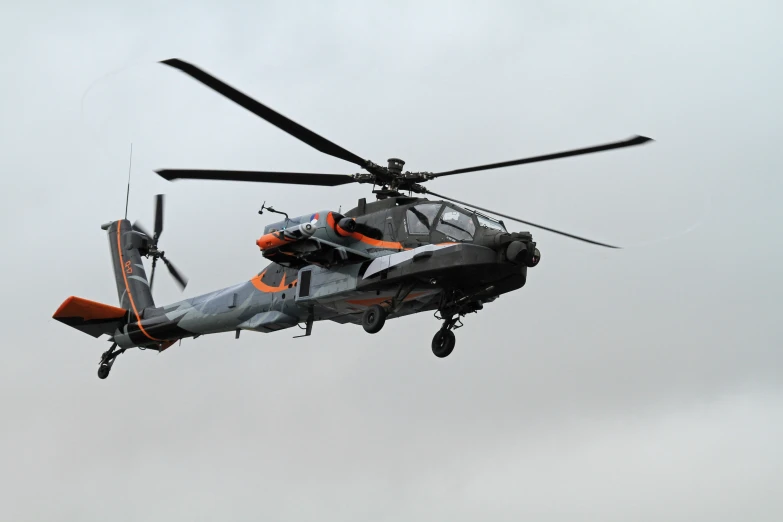 a grey and orange helicopter flying in the air