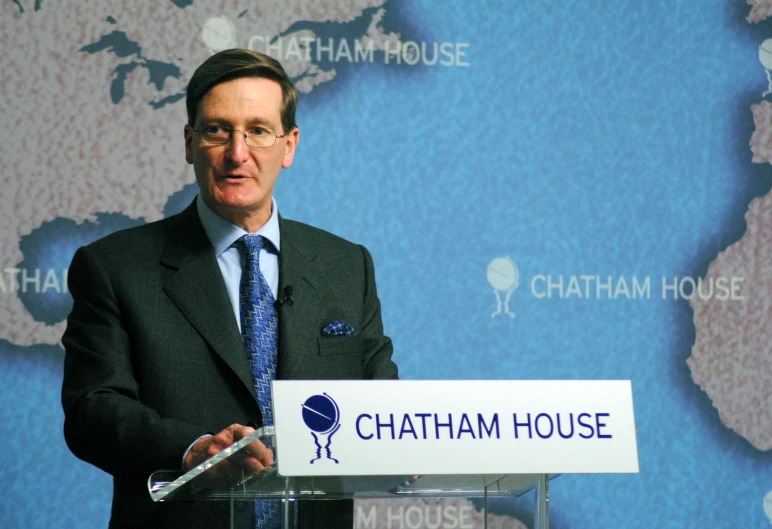 a man giving a speech in front of a map