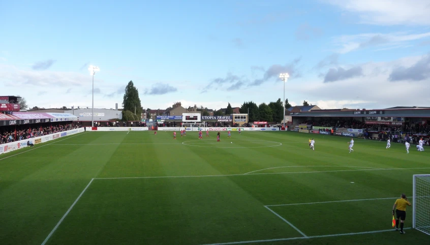 an outdoor soccer field surrounded by lots of people