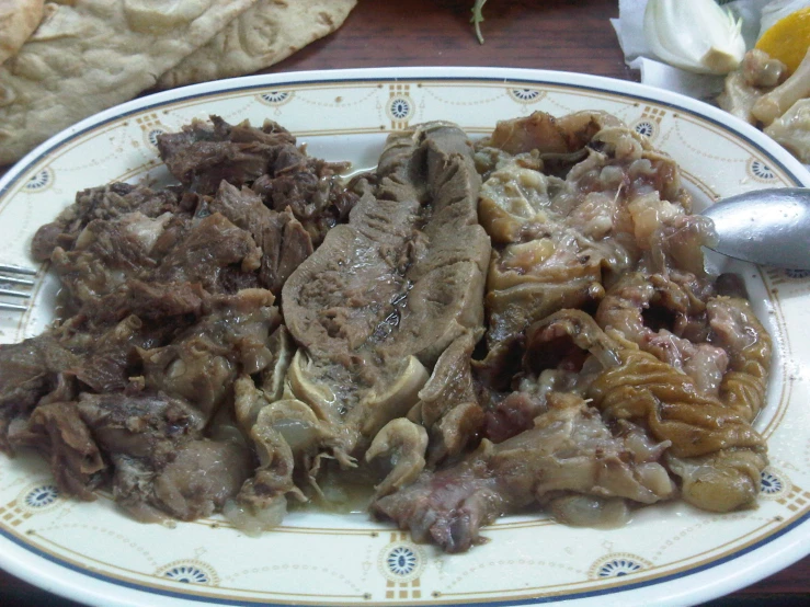 a close up of a plate of food with meat and other foods
