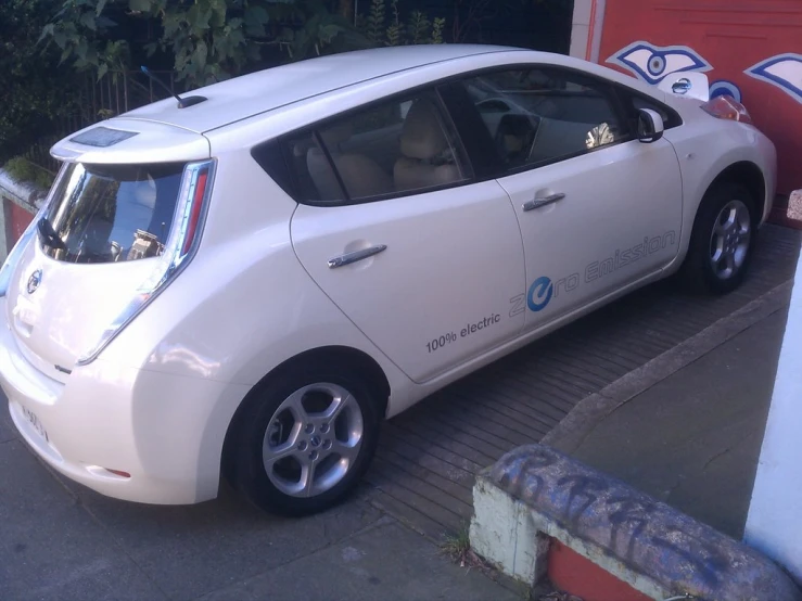 a white nissan leaf electric car parked outside