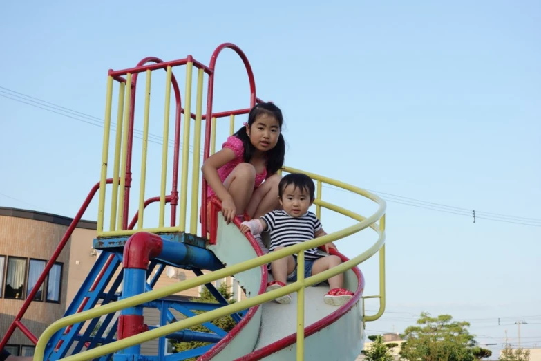 three little s standing on the edge of a slide