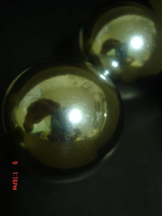 two chrome balls sitting next to each other on a black surface