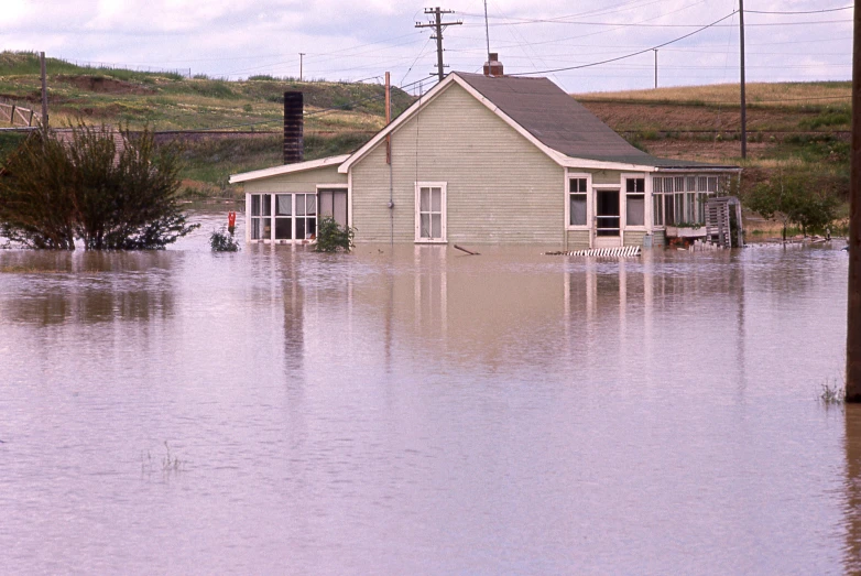 houses surrounded by flood waters and some telephone poles