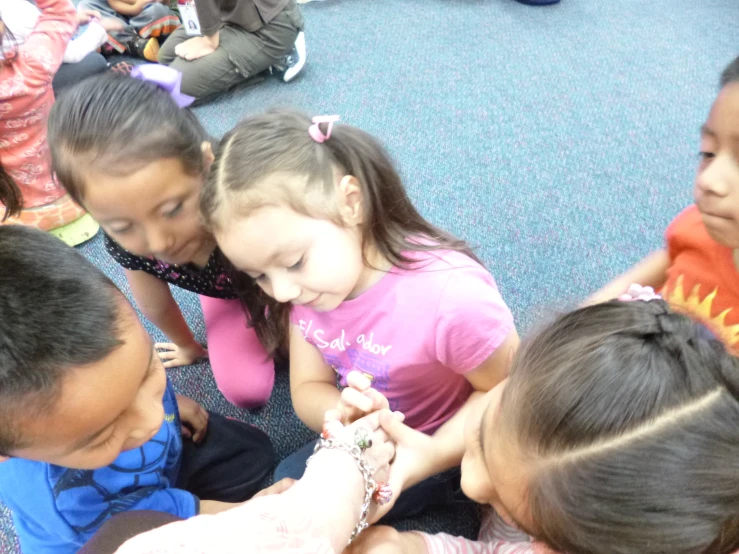 a group of children sitting in a circle playing with each other