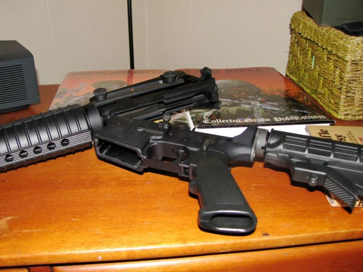 an ar - 15 and pistol, which is resting on a desk