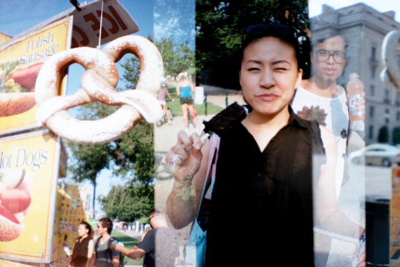 the asian woman holds a pretzel in her hand