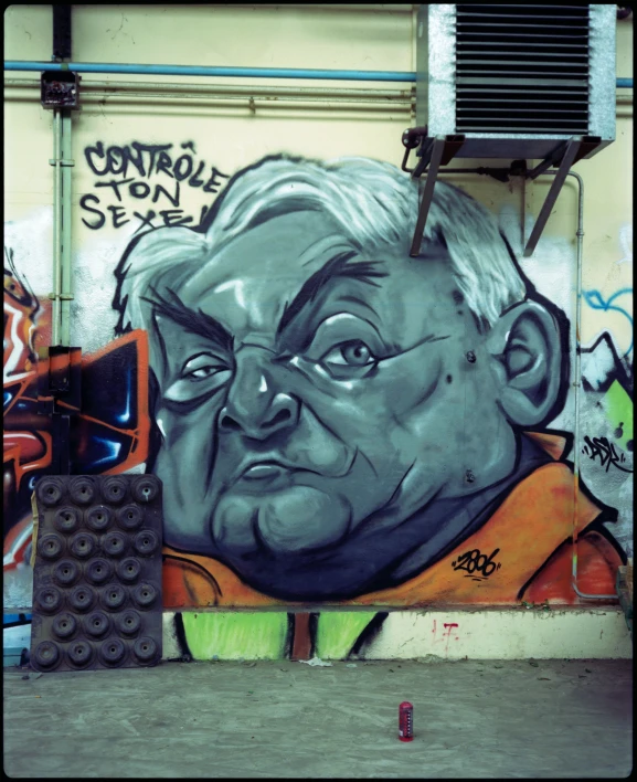 an old man's face next to some graffiti