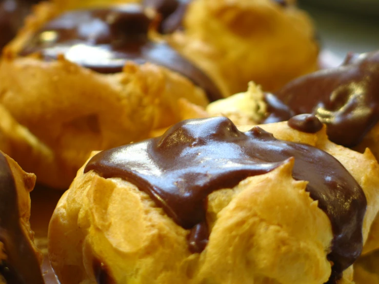 a group of doughnuts covered in chocolate on top of each other