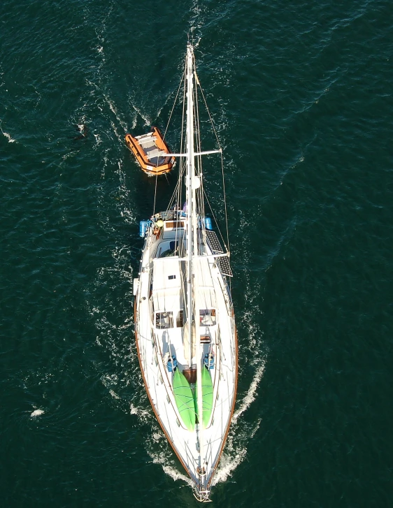 an overhead s shows a yacht and small boat, seen from above