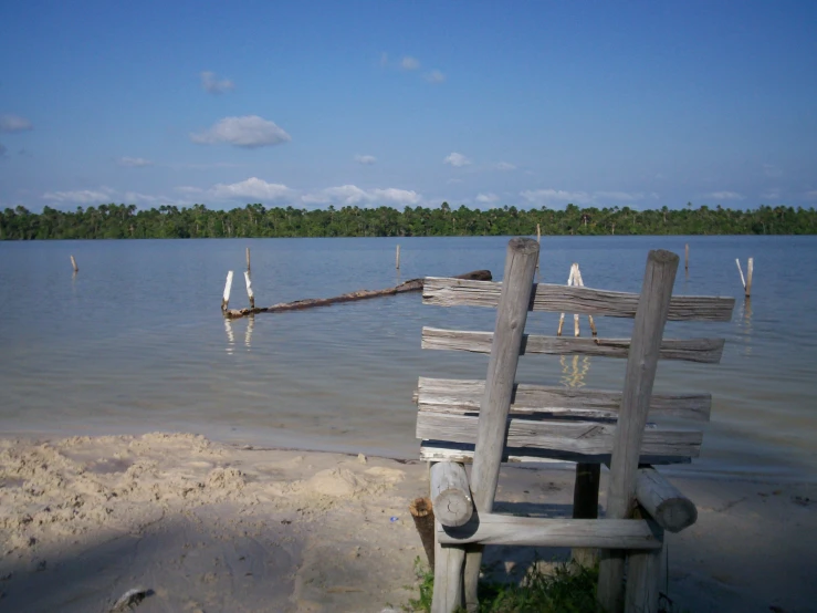 an empty bench sitting next to the ocean