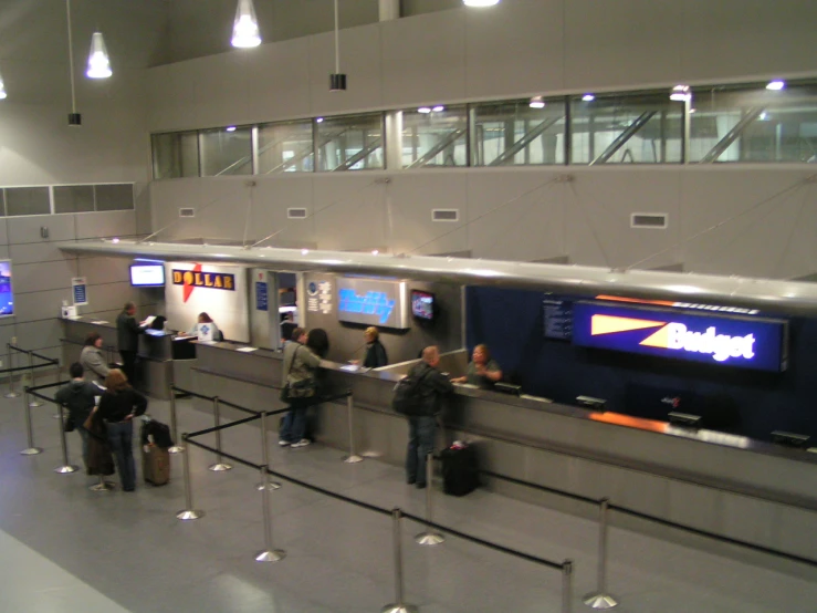 the people are waiting in the line at the baggage claim