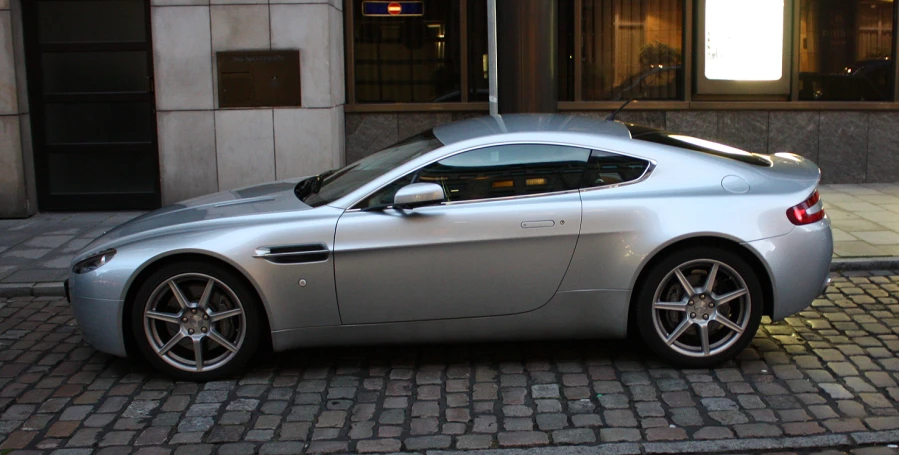 the front view of a silver sports car in the street