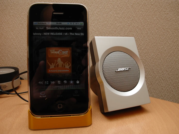 an electronic device next to a small speaker and cell phone