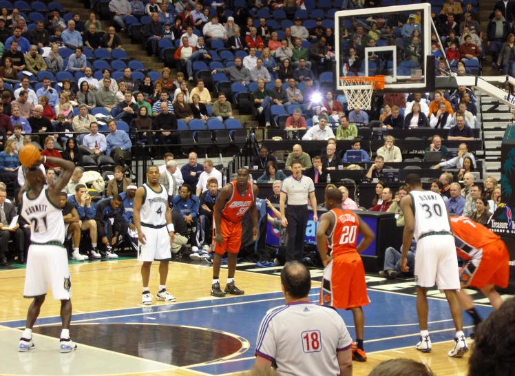 a group of men in basketball uniforms playing basketball