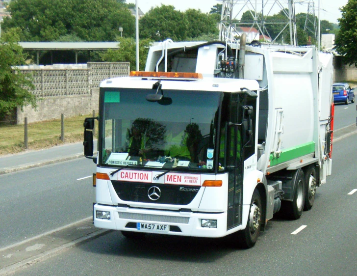 a trash truck driving down the road in traffic