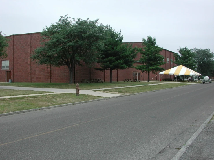 a street with a building and trees next to it