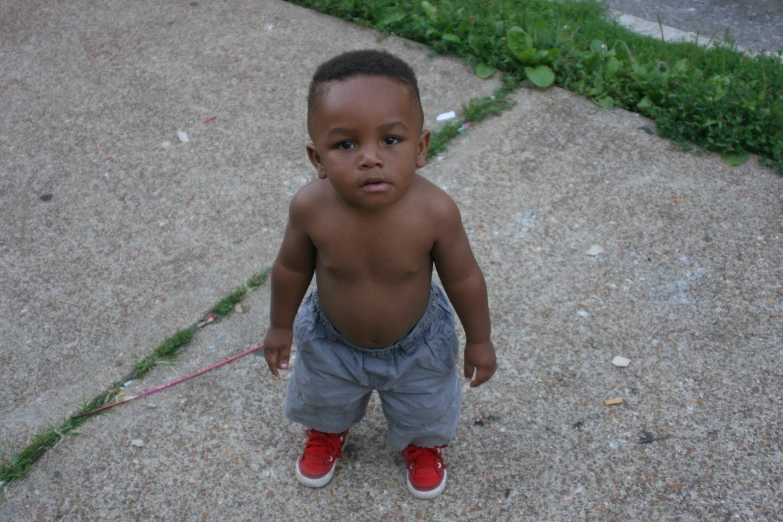 a small child standing on top of a sidewalk