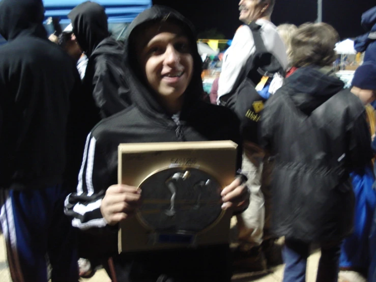 a young man in a hooded sweatshirt holding a picture