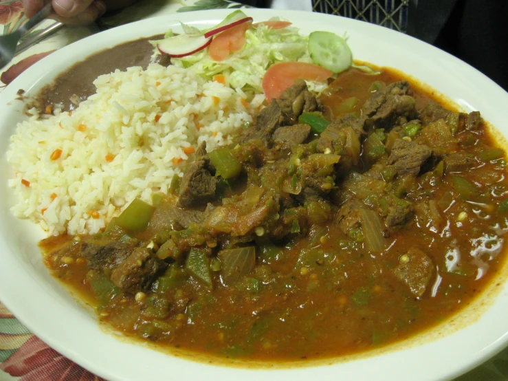 a white plate topped with rice and meat