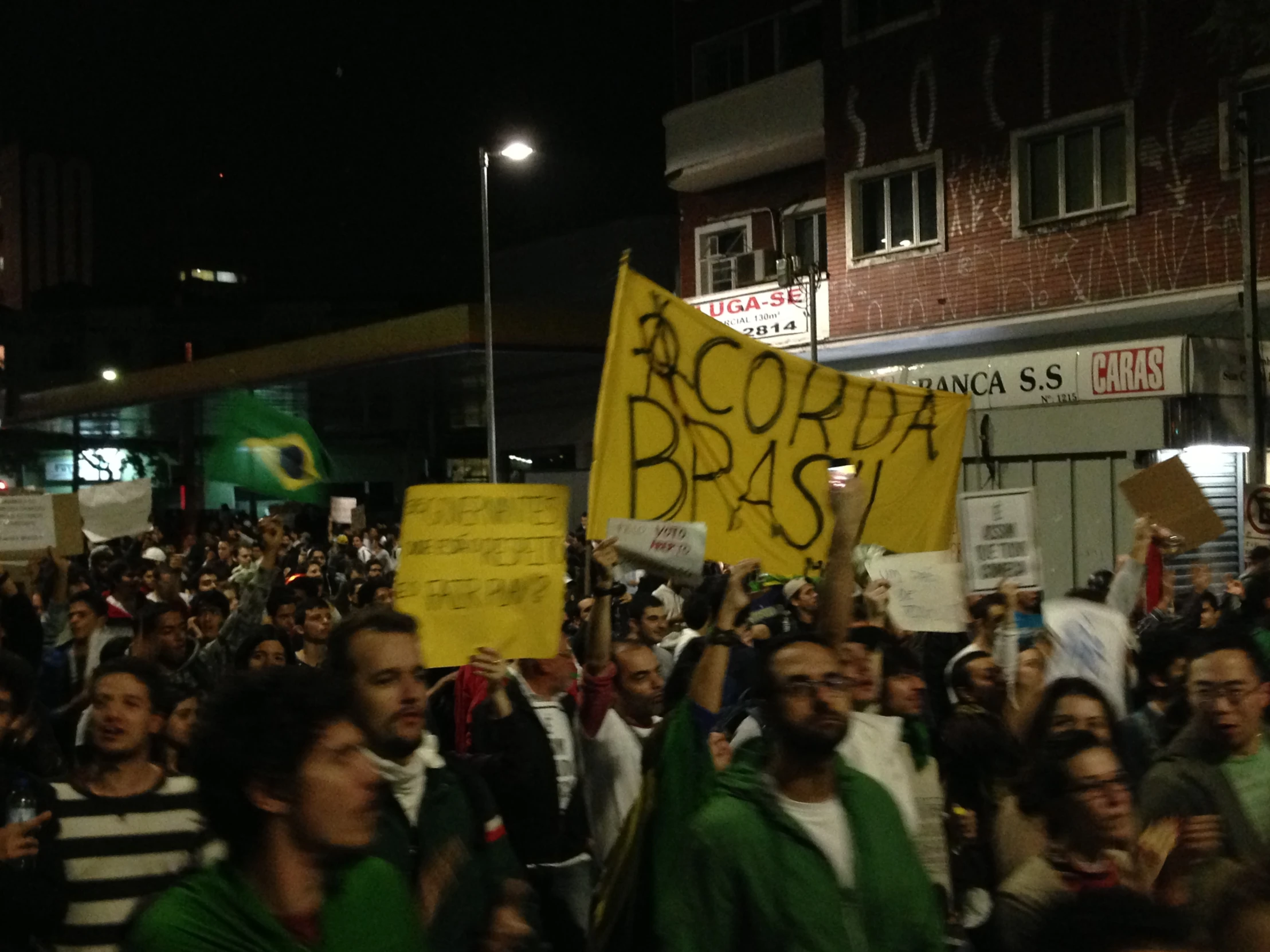 people holding signs in front of a building at night