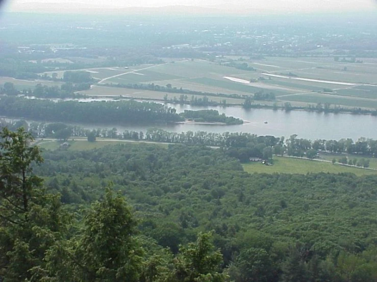 a view of trees, a river, and some hills