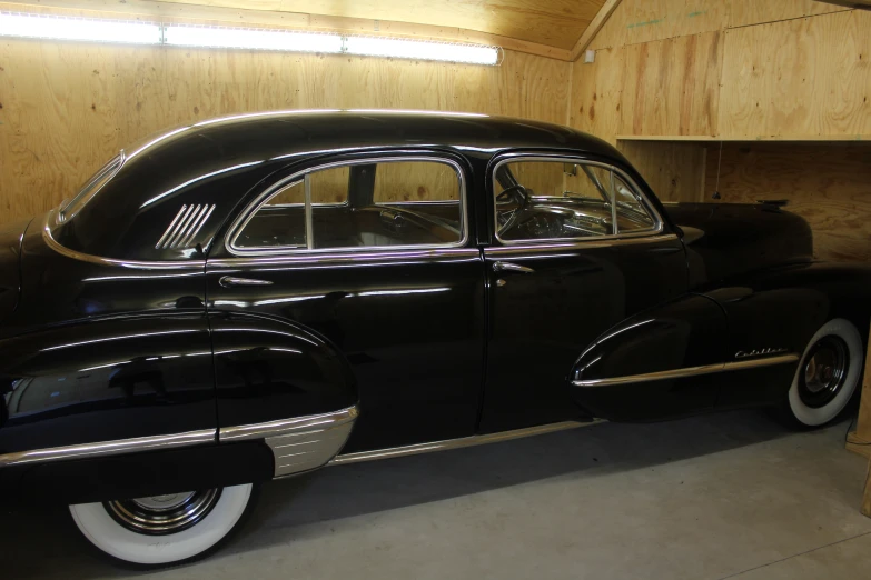 an old classic car is parked inside a garage