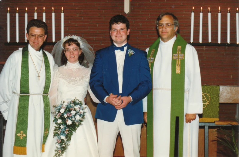 a married couple standing with priest, and bride