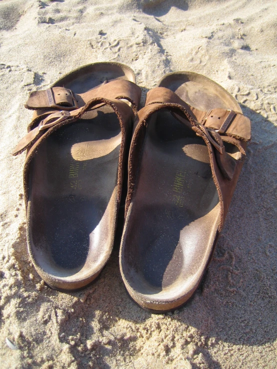a pair of shoes on a beach sand area