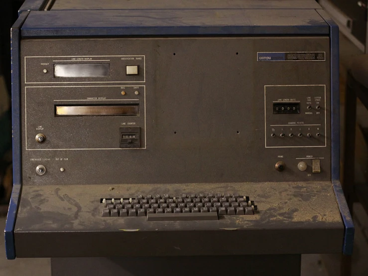 an old, black computer with a keyboard and a remote control