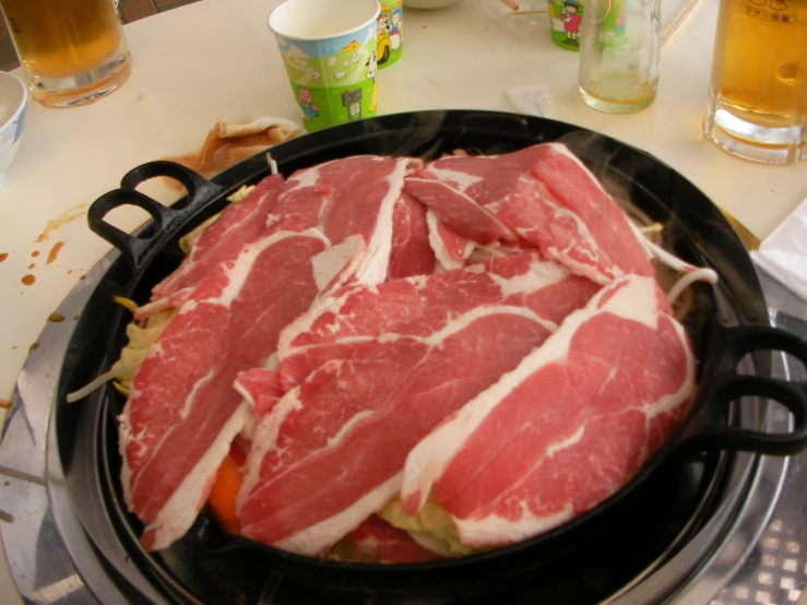 a piece of raw meat is being fried on a stove top