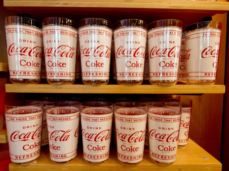 the jars are lined up and have coca - cola labels