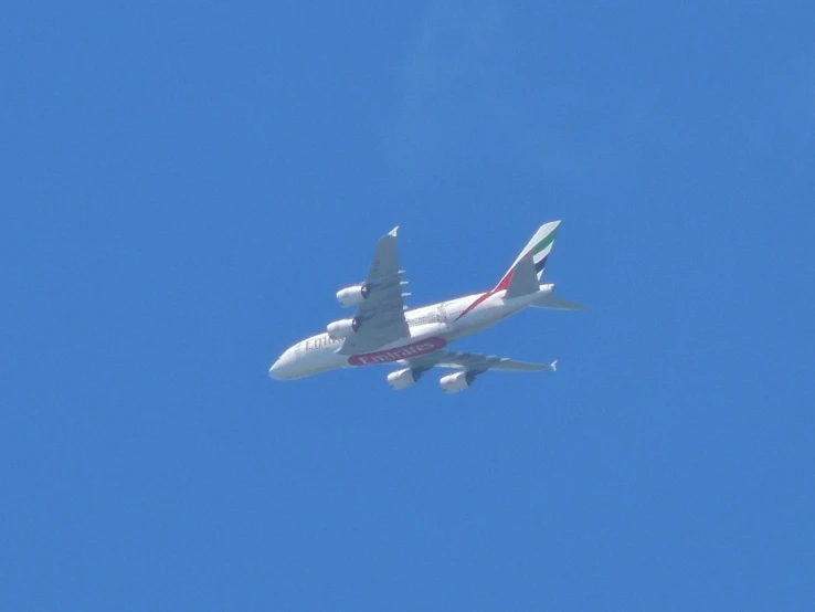 an airplane flying high in the blue sky