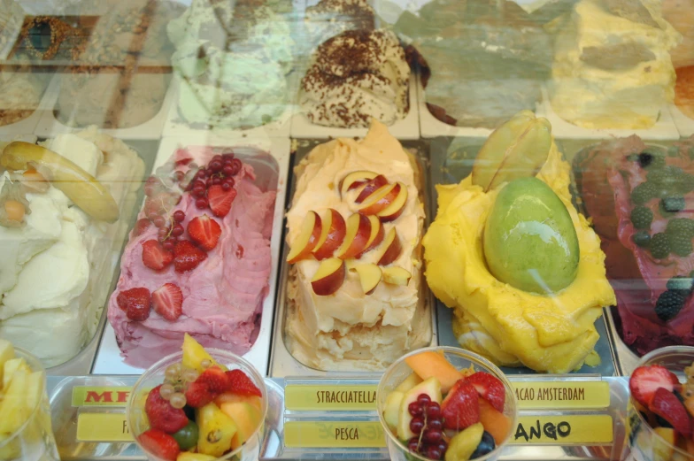 a window display with assorted flavored desert items in trays