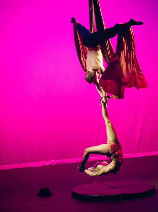 a woman performs a handstand on a pole