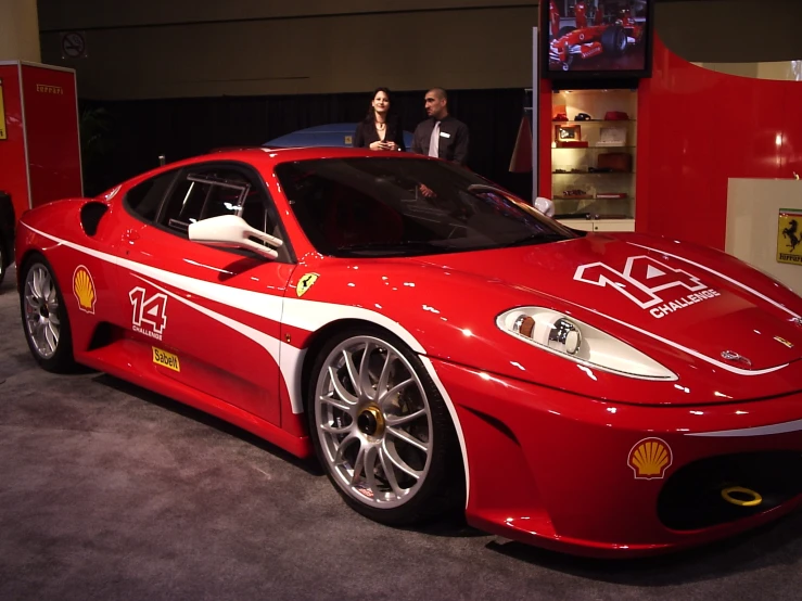 a ferrari race car parked on display in front of some people