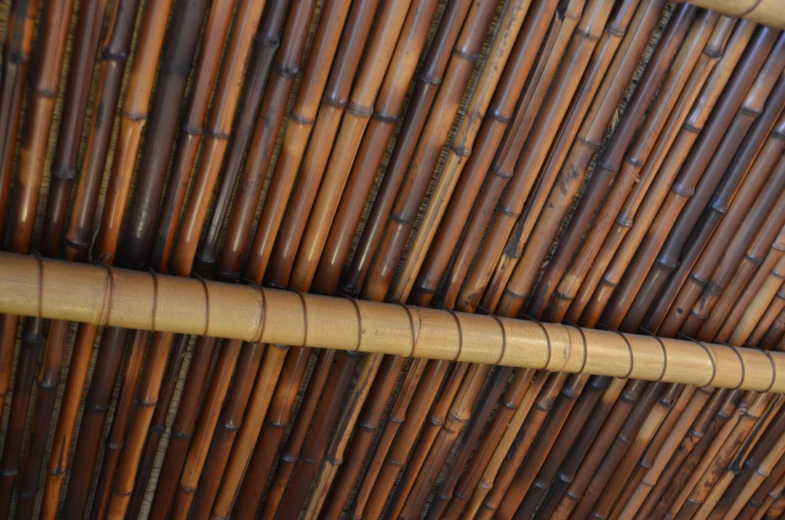 a brown bamboo ceiling made up with two sections of dark wooden sticks