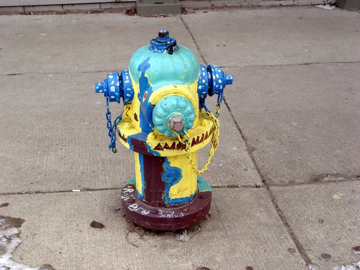 a blue and yellow fire hydrant is on the sidewalk