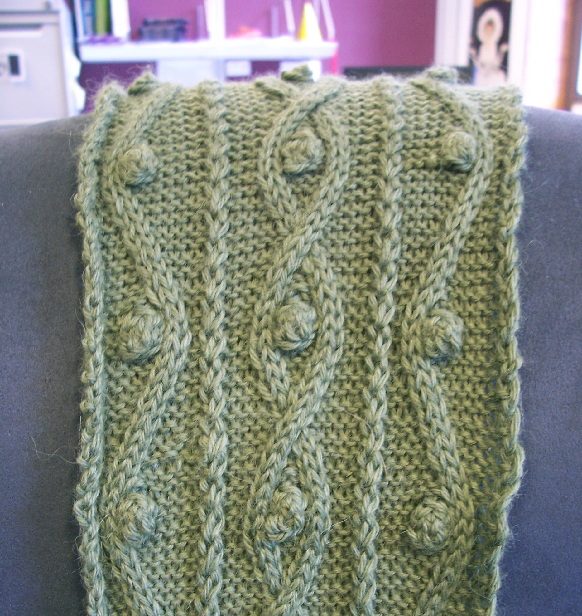 a green sweater with a decorative pattern on it