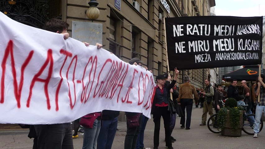 several people standing around in a city holding banners