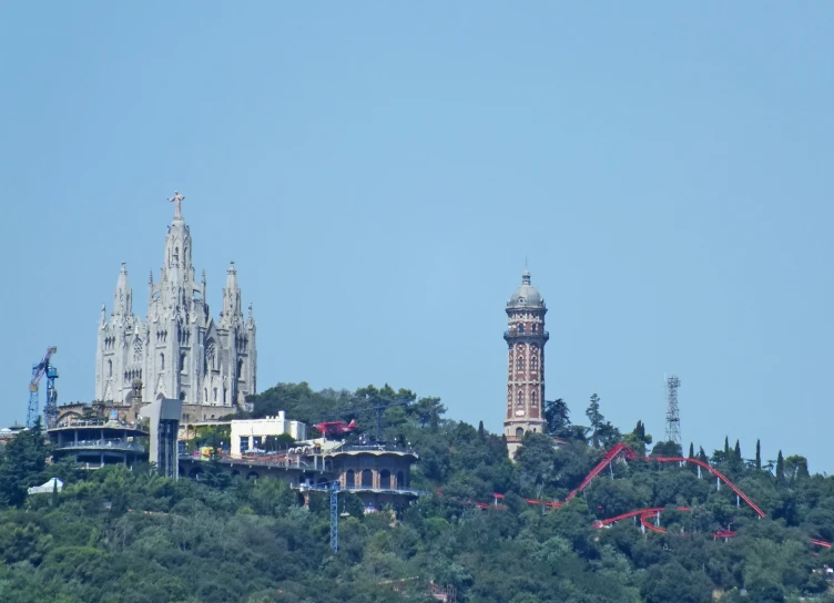 a castle on top of a mountain with a roller coaster in front