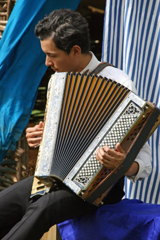 a man playing the accordion while sitting on a chair