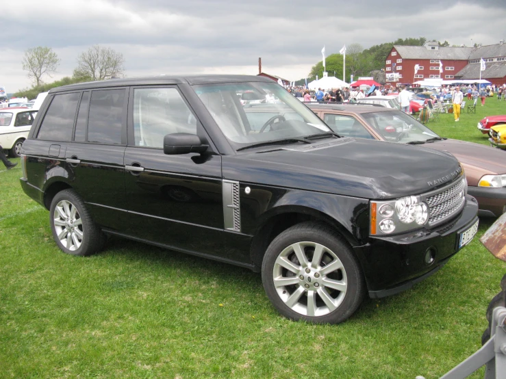 several cars parked on grass in a line