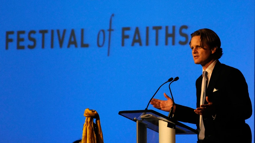 a man in suit standing at a podium