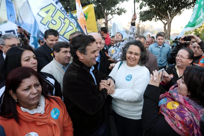 a crowd gathered in front of a sign waving